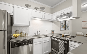 New home upgrades include: quartz countertops, stainless steel energy-efficient appliances, a white hexagon tile backsplash, gray hand-scraped wood-style flooring, brushed nickel hardware, undermount sinks, gooseneck faucets, and upgraded carpet in bedrooms.